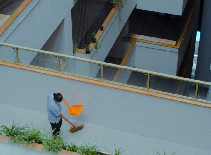 A man with a broom is sweeping the street